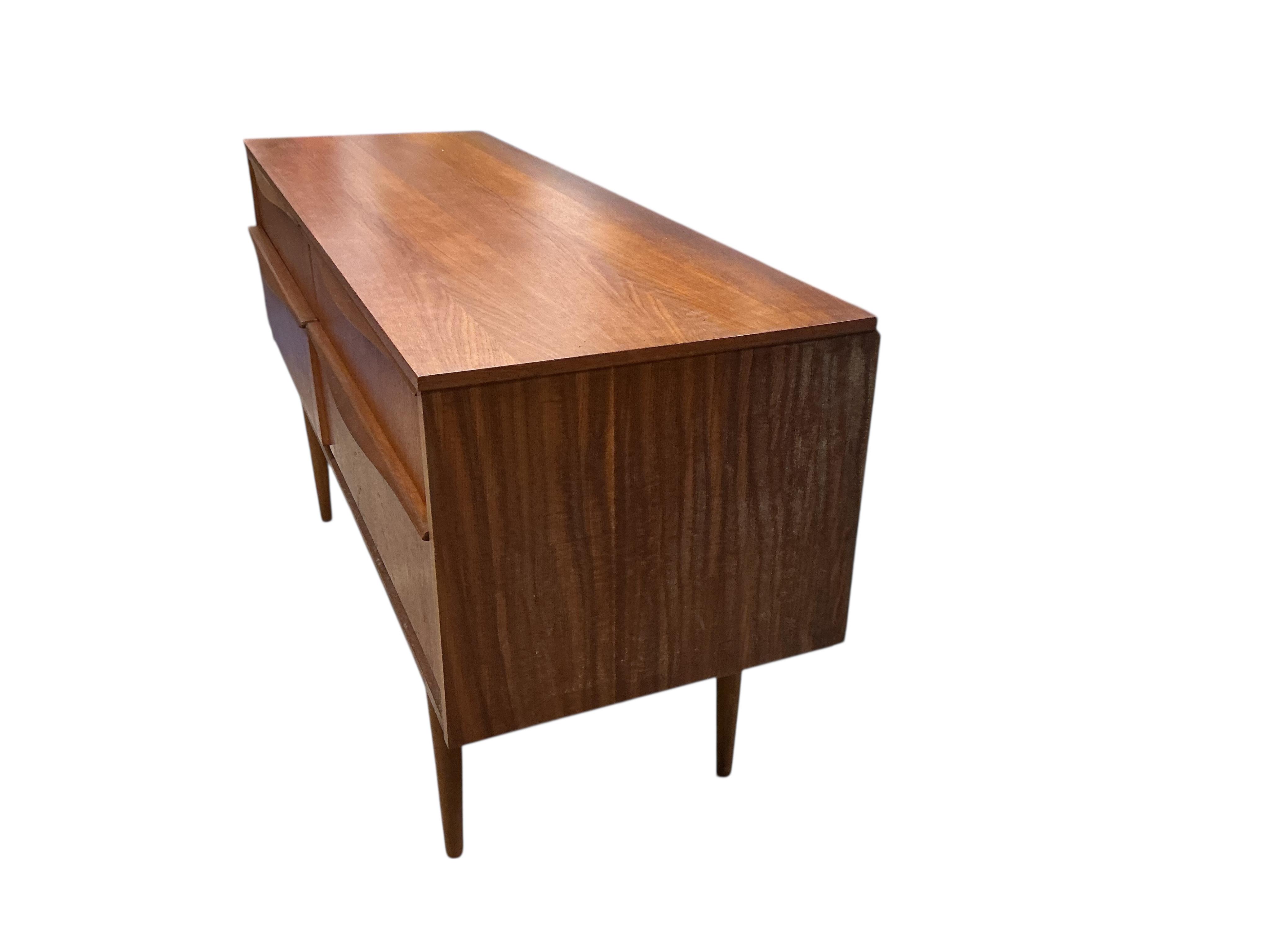 A mid century teak four drawer chest, width 124cm, depth 42cm, height 66cm